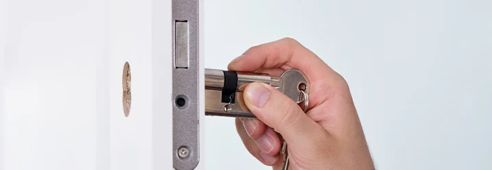 Person wechselt einen Türzylinder.